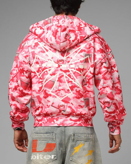 Person wearing a pink and white camouflage jacket on a gray background