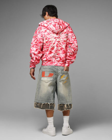 Person wearing a pink and white tie-dye hoodie and gray shorts with a brand logo on a gray background