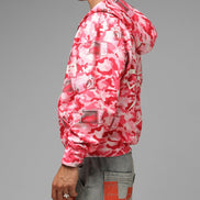 Person wearing a pink and white camouflage jacket on a gray background