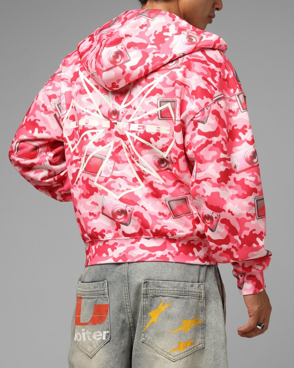 Person wearing a pink and white camouflage jacket on a gray background