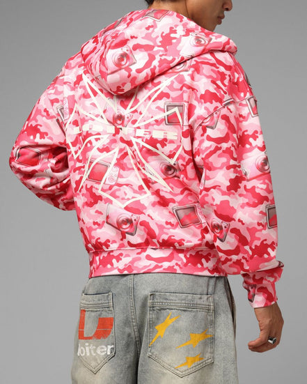 Person wearing a pink and white camouflage jacket on a gray background