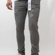 Person wearing gray distressed jeans with a white background