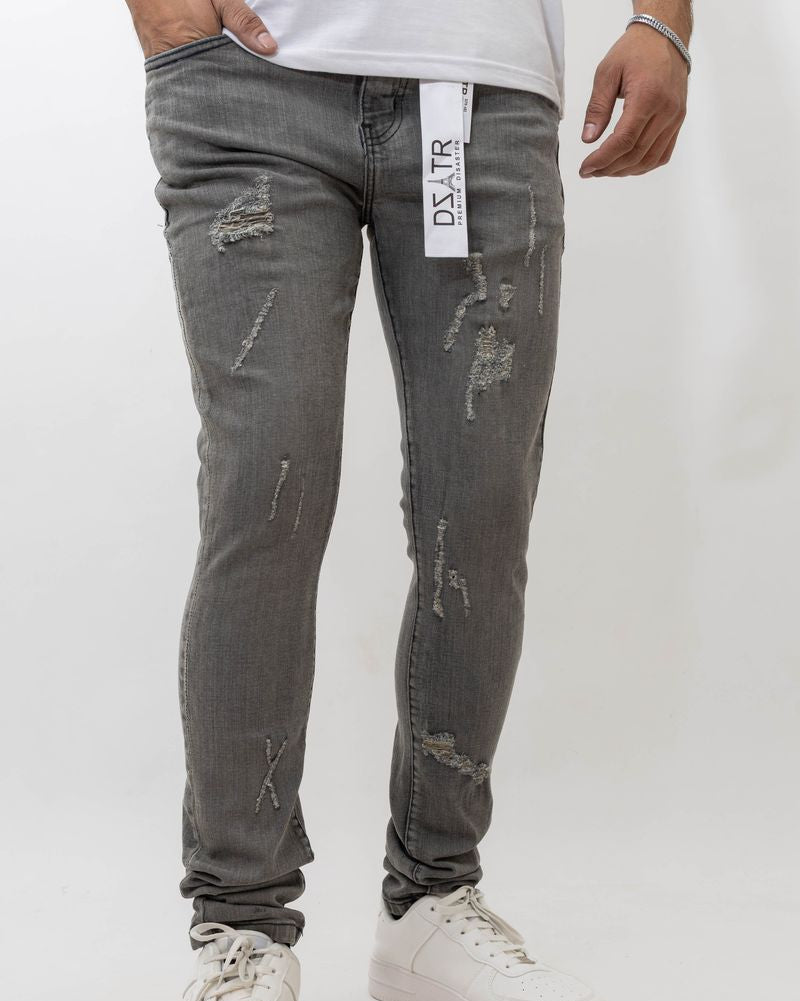 Person wearing distressed gray jeans with a brand label on a white background
