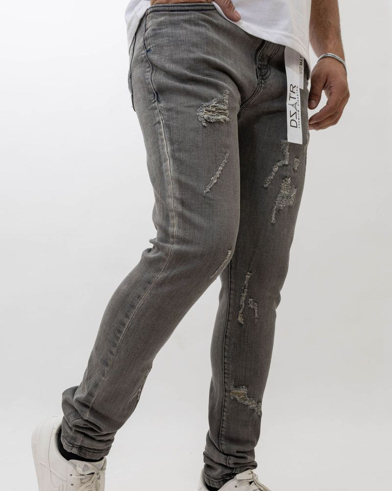 Person wearing gray distressed jeans with a white background