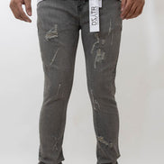 Person wearing gray distressed jeans with a visible brand label on a white background