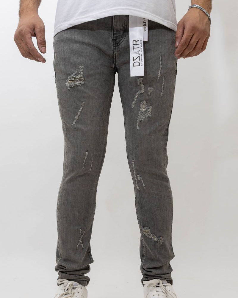 Person wearing gray distressed jeans with a visible brand label on a white background