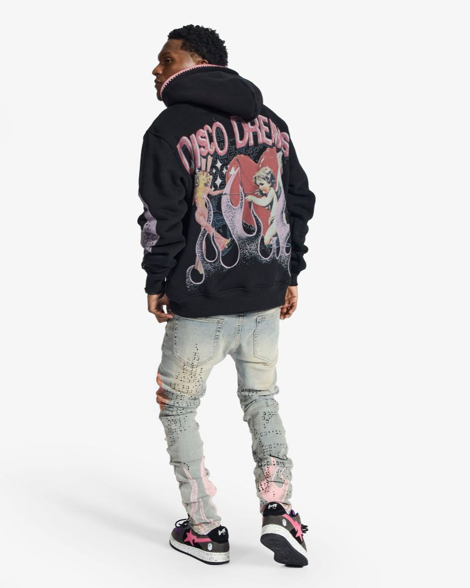 Person wearing a black hoodie with graphic design on the back, standing against a white background