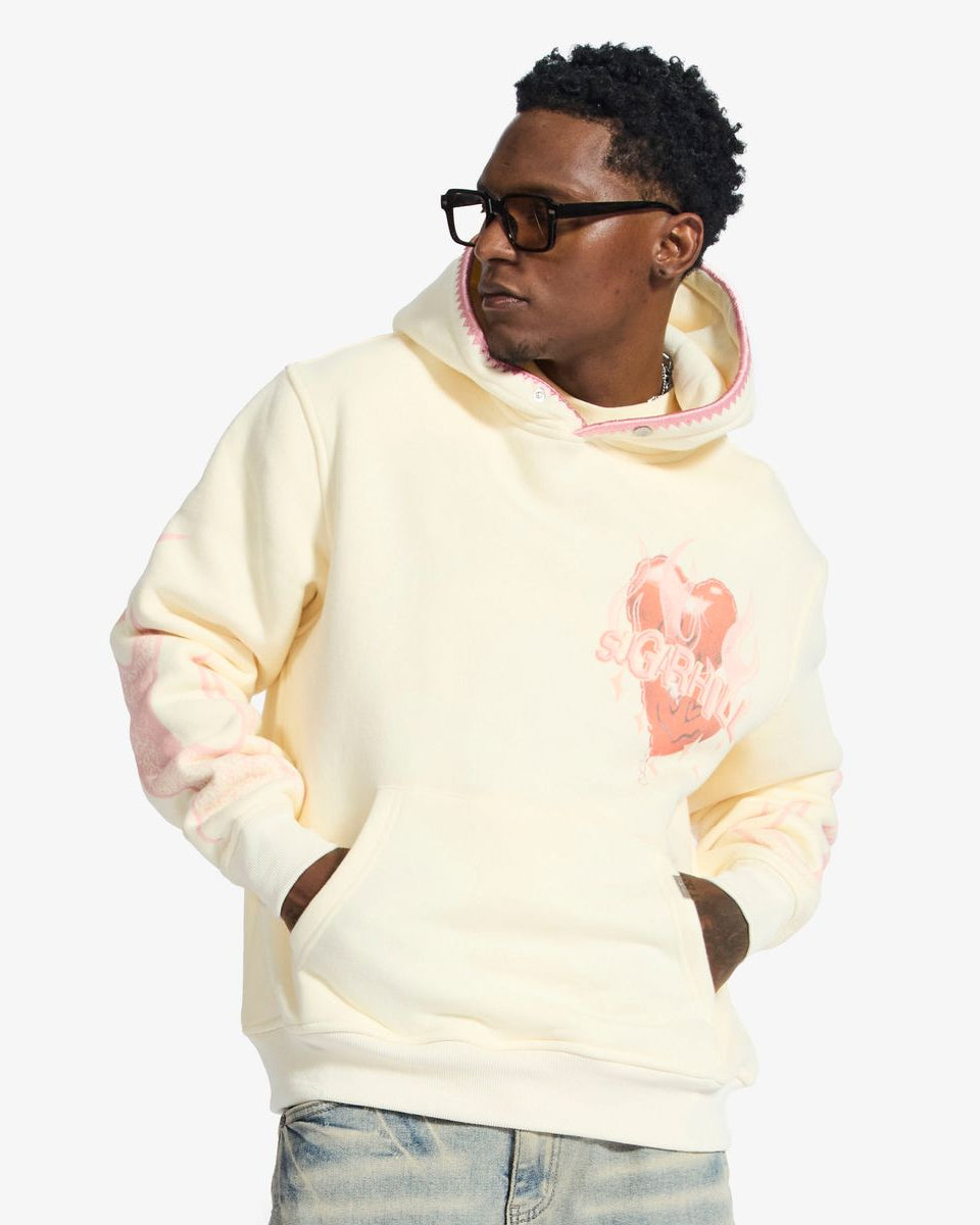 Person wearing a light-colored hoodie with a graphic design on a white background
