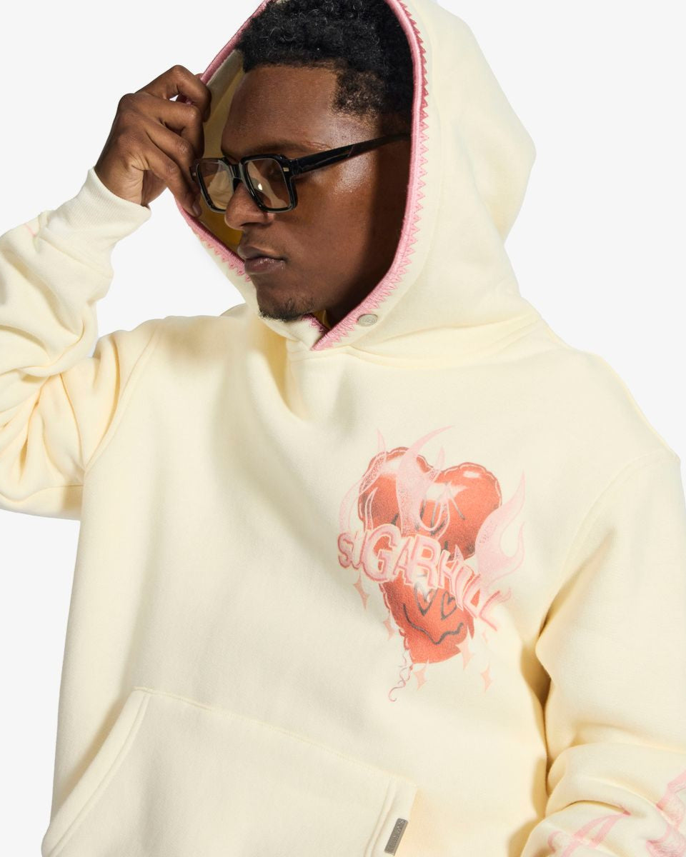 Person wearing a light-colored hoodie with a graphic design on a white background