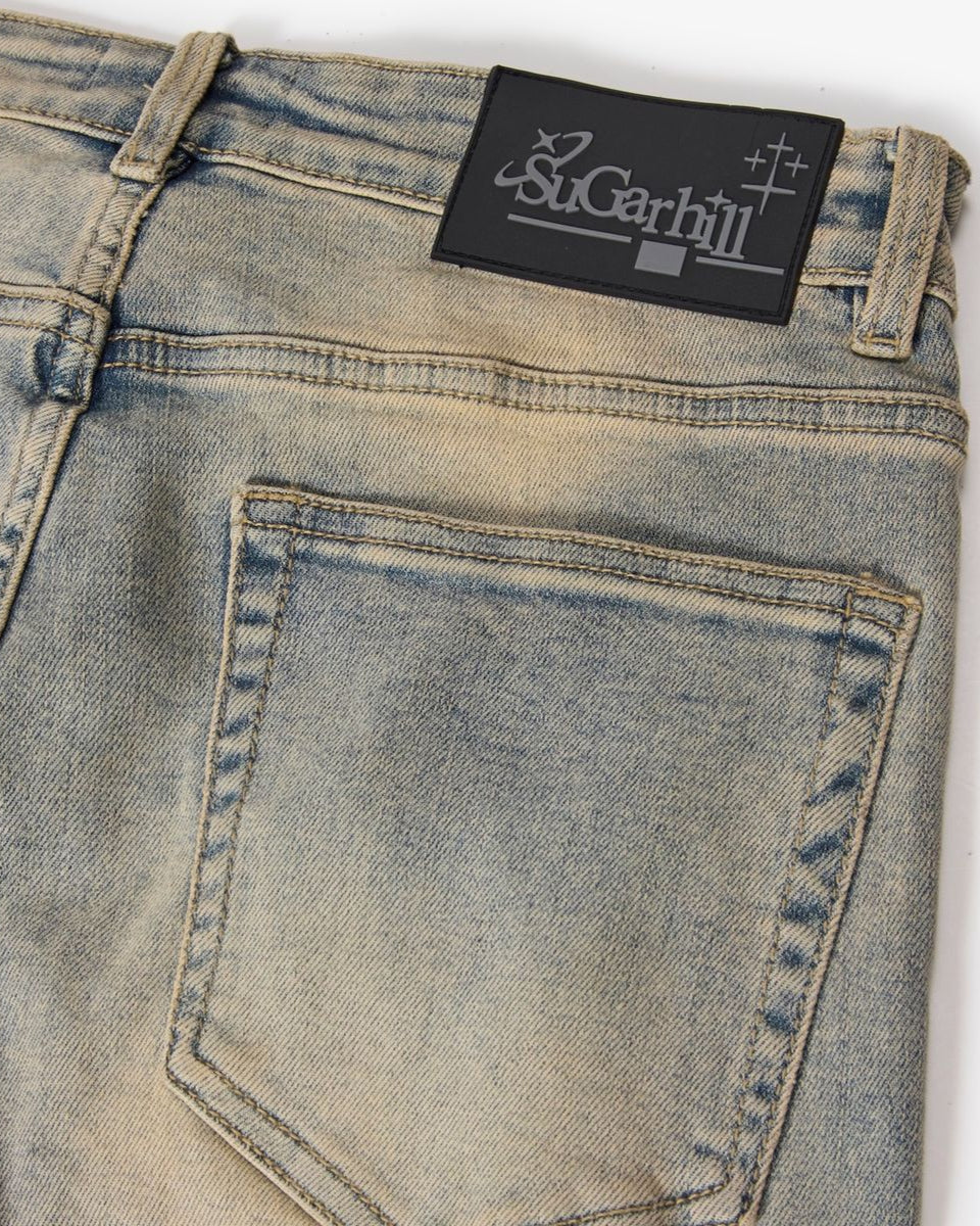 Close-up of a pair of jeans with a Sugarhill label on a white background