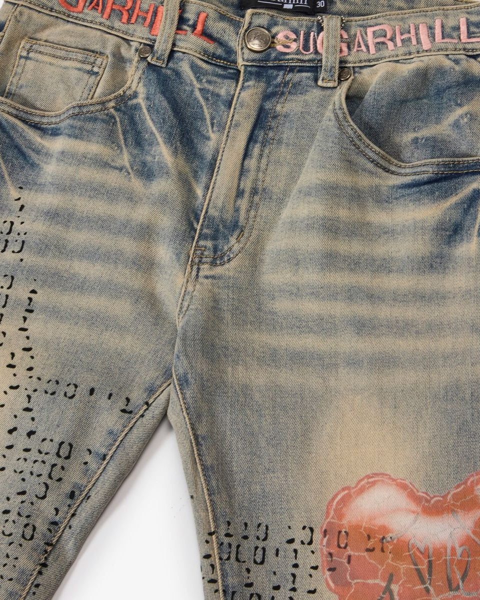 Distressed denim jeans with visible branding on a white background