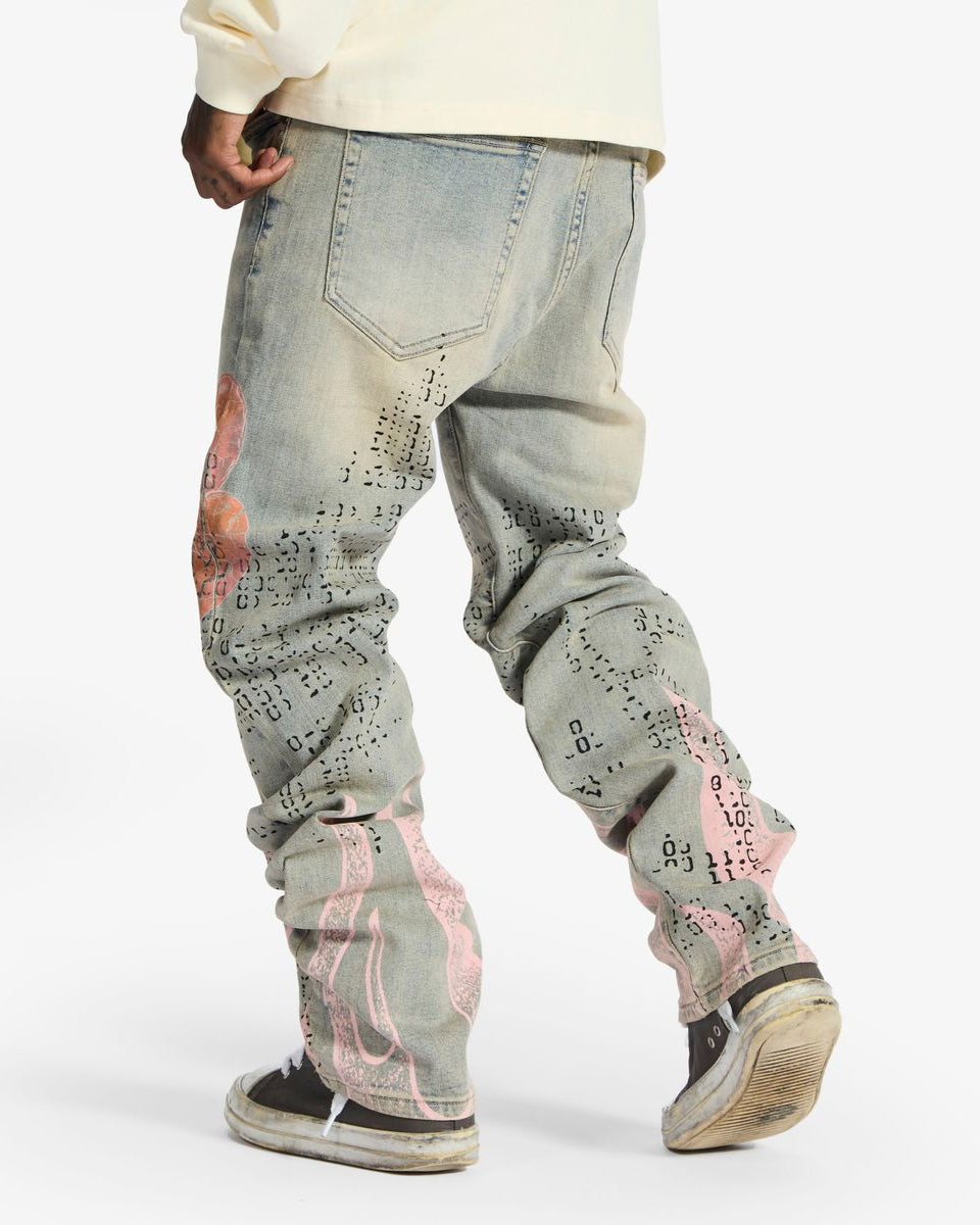 Person wearing light blue jeans with graffiti-style designs on a white background