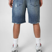 Person wearing blue denim shorts on a white background