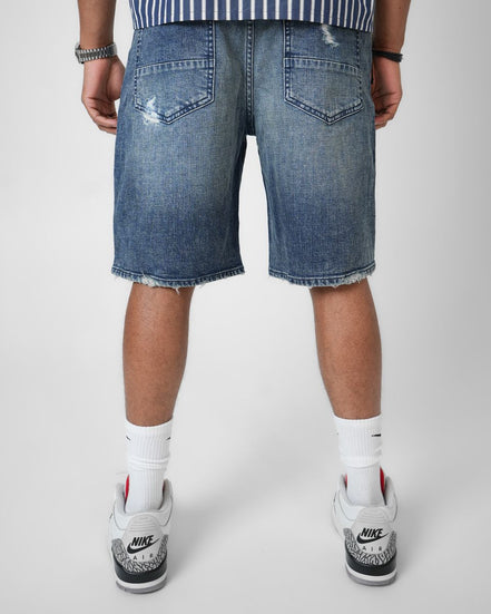 Person wearing blue denim shorts on a white background