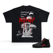 A black graphic t-shirt featuring a horror-themed print with the text 'Don't Forget To Wash Your Hands' and red dripping blood, shown alongside a black and red sneaker on a white background.