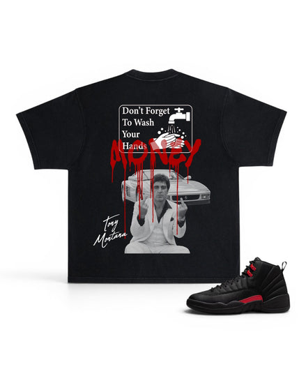 A black graphic t-shirt featuring a horror-themed print with the text 'Don't Forget To Wash Your Hands' and red dripping blood, shown alongside a black and red sneaker on a white background.