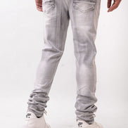 Person wearing light gray jeans and white sneakers on a white background