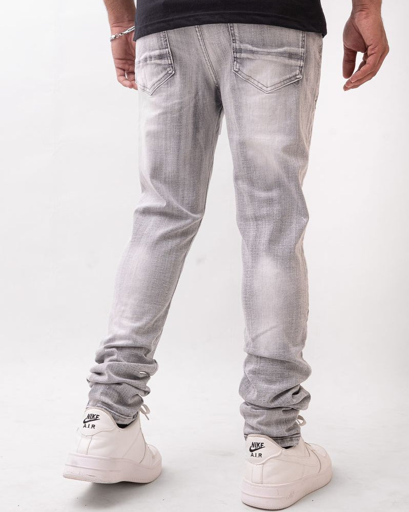 Person wearing light gray jeans and white sneakers on a white background