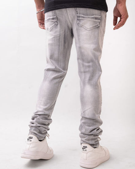 Person wearing light gray jeans and white sneakers on a white background