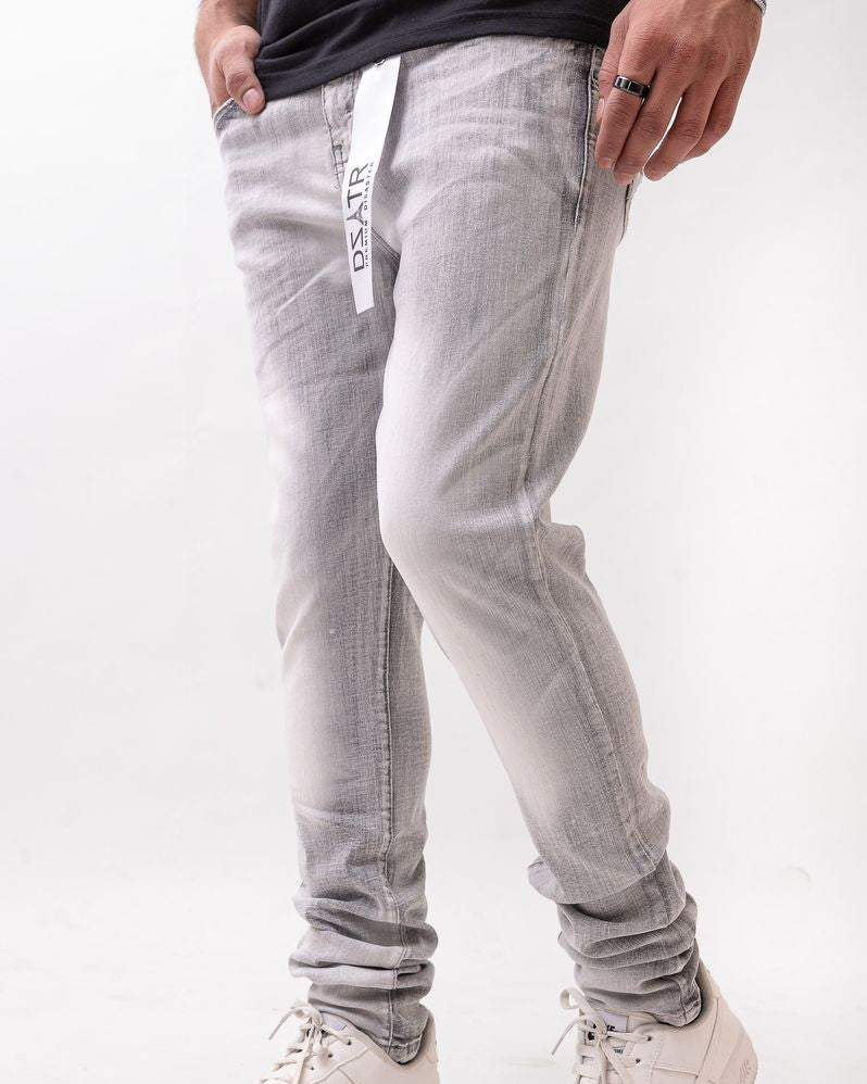 Person wearing light gray jeans with a subtle pattern and white sneakers on a white background