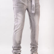 Person wearing light gray jeans with a visible brand label on a white background