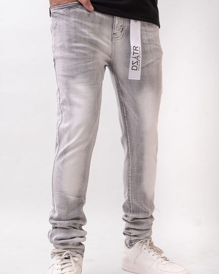 Person wearing light gray jeans with a visible brand label on a white background