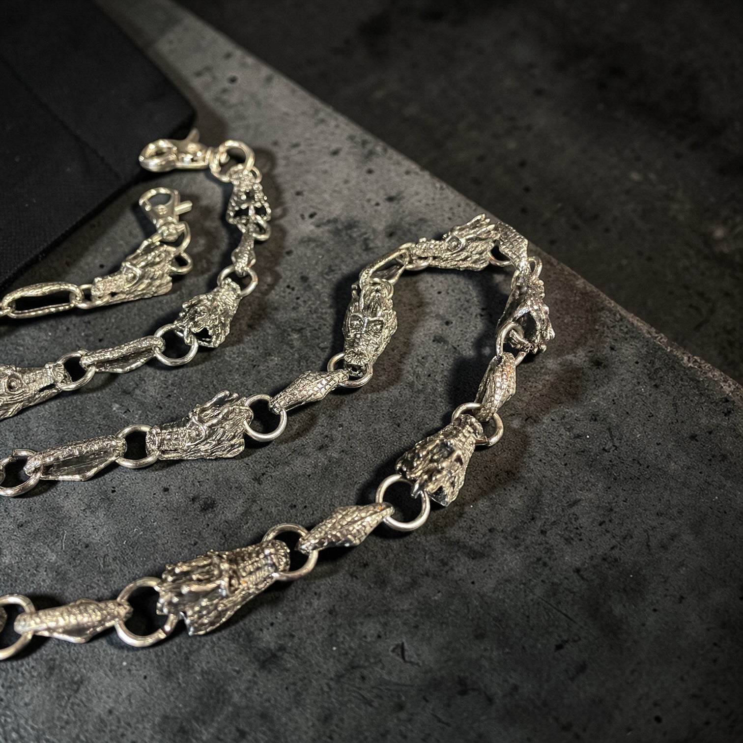 Silver WALLET chain on a dark textured surface