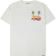 An off-white short-sleeve t-shirt with a colorful chest graphic featuring two green palm trees, a yellow surfboard, and the red text 'ALMOST SOMEDAY'.