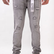 Person wearing gray distressed jeans with a brand label on a white background