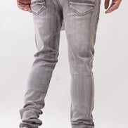 Person wearing gray jeans and white sneakers on a white background
