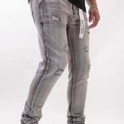 Person wearing gray distressed jeans with a white background