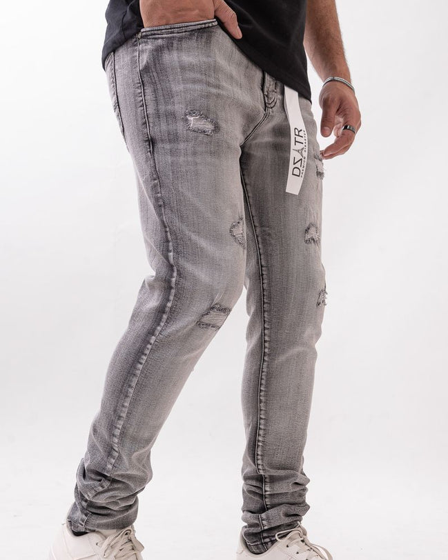 Person wearing gray distressed jeans with a white background