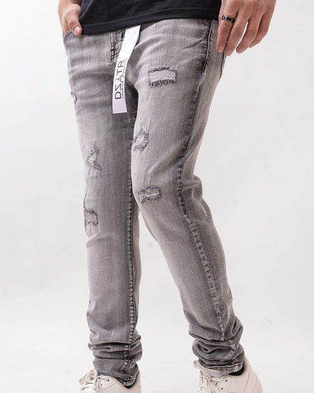 Person wearing gray distressed jeans with a white background