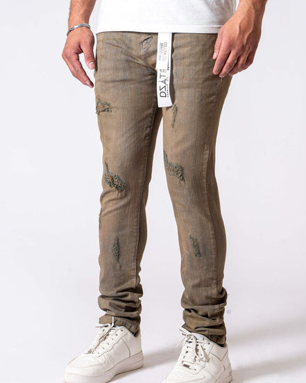 Person wearing beige distressed jeans with a white background