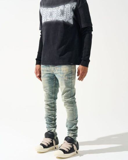 Person wearing a black sweater with white pattern and light blue jeans on a white background