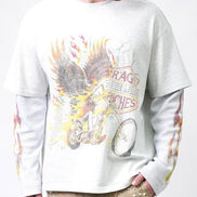 A man wearing a white long-sleeve t-shirt with a distressed graphic print of a motorcycle, flames, and wings, layered over a white long-sleeve base shirt. The photo is cropped from the chin down against a plain white background.