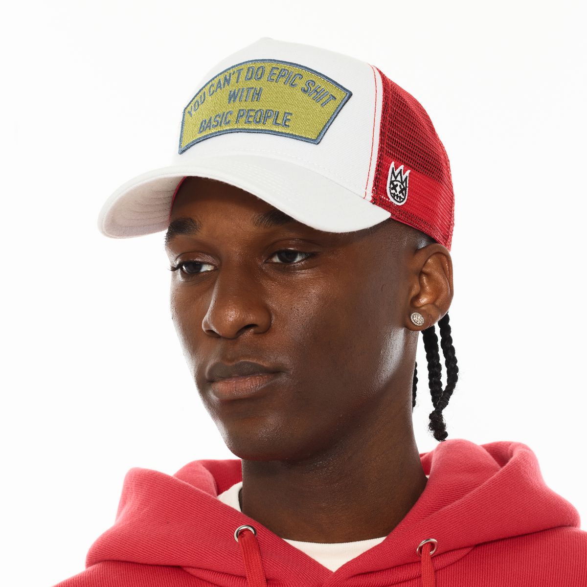 person wearing a yellow, red, and white trucker hat with wording on it with a white background. 