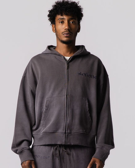 A man wearing a dark gray zip-up hoodie and matching sweatpants with 'setnile' printed on the chest, photographed against a solid light gray background.