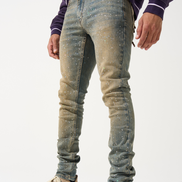 Person wearing distressed blue jeans and beige sneakers on a white background
