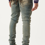 Person wearing distressed blue jeans and brown shoes on a white background