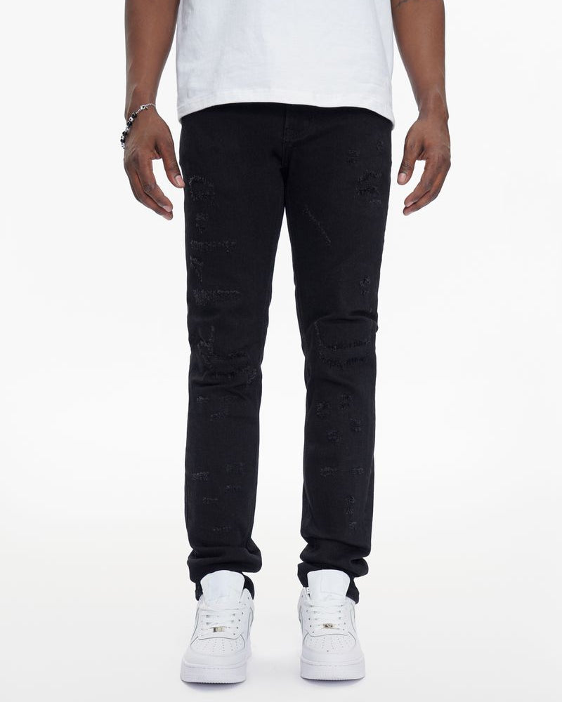 Person wearing black jeans and white sneakers on a white background
