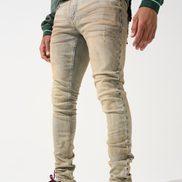 Person wearing beige jeans and maroon sneakers on a white background
