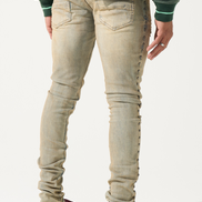 Person wearing beige jeans and maroon sneakers on a white background