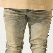 Beige jacket with blue abstract design and distressed jeans on a white background