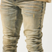 Close-up of beige jeans with a plain background