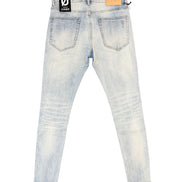 Back view of light-wash denim skinny jeans with a black and white brand patch on the right waistband and a tan leather patch on the left waistband, shown flat on a white background.