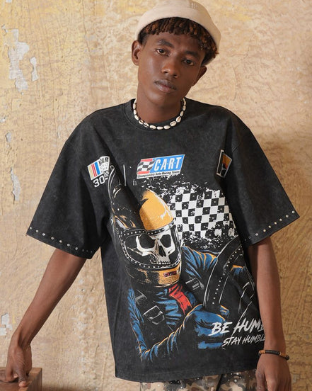 Person wearing a black graphic t-shirt with a colorful design against a textured wall.