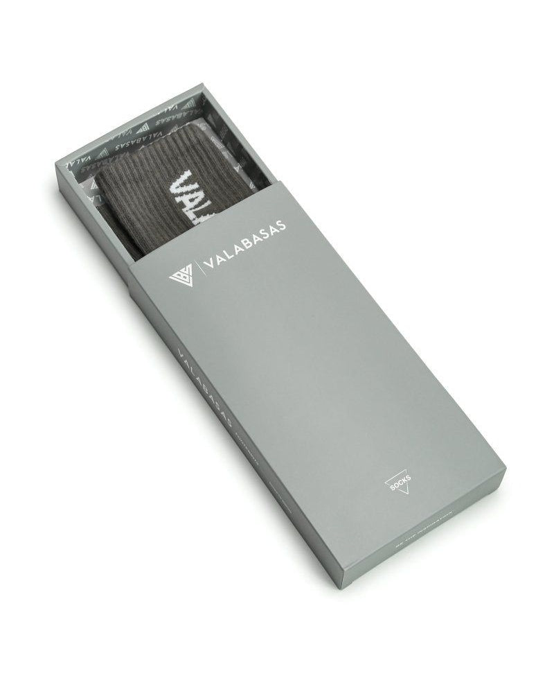 Gray box with a grey item inside, branded 'VALABASAS', on a white background