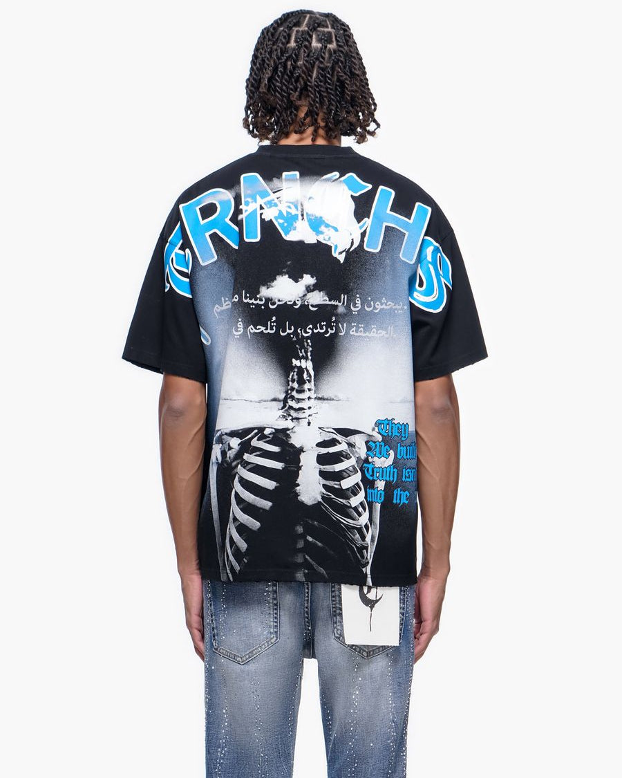 Person wearing a black t-shirt with a graphic design on the back, featuring text and a skeleton.