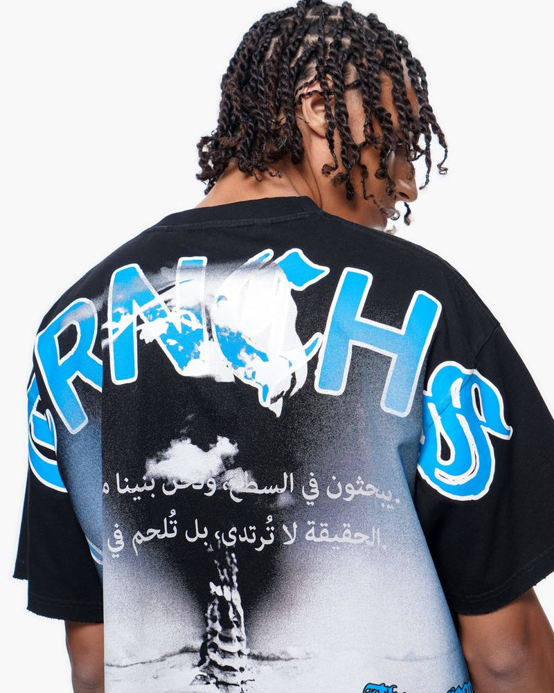 Person wearing a black t-shirt with blue text and graphics on the back